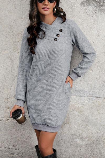 a woman in a gray sweater dress holding a coffee cup