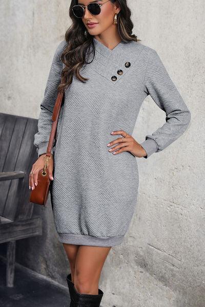 a woman wearing a gray sweater dress and black boots