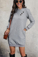 a woman wearing a gray sweater dress and black boots