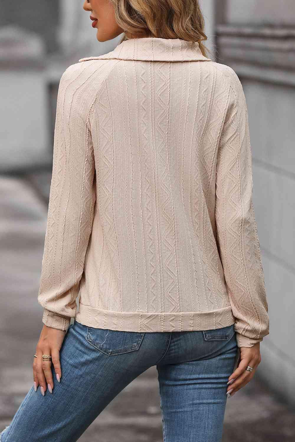 a woman wearing a beige sweater and jeans