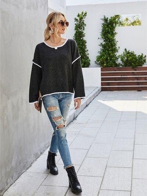 a woman wearing ripped jeans and a black sweater