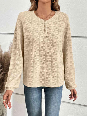 a woman wearing a beige sweater and jeans