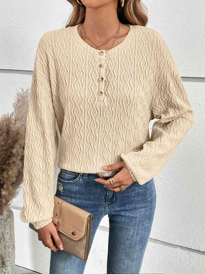 a woman wearing a beige sweater and jeans