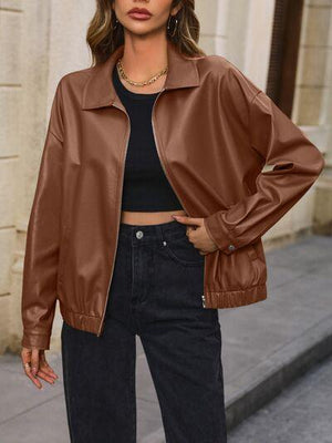 a woman wearing a brown leather jacket and jeans