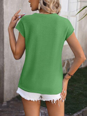 a woman wearing a green top and white shorts