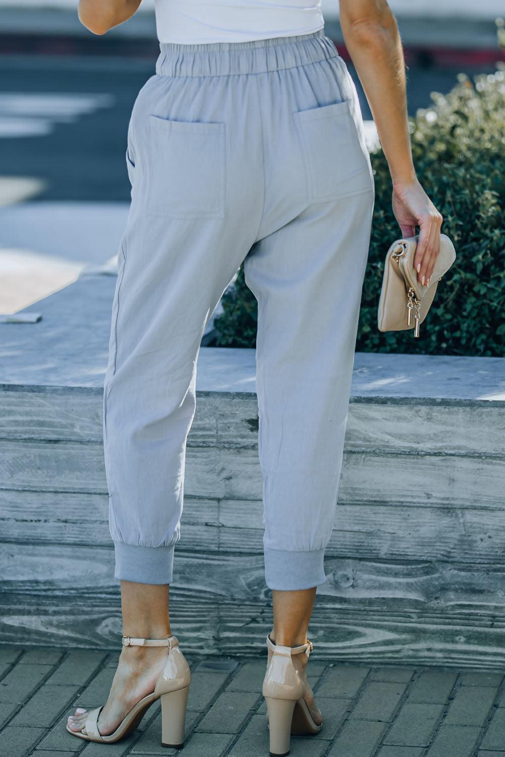 a woman wearing a white top and blue pants