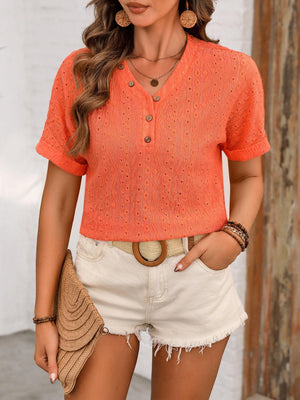 a woman wearing an orange shirt and white shorts