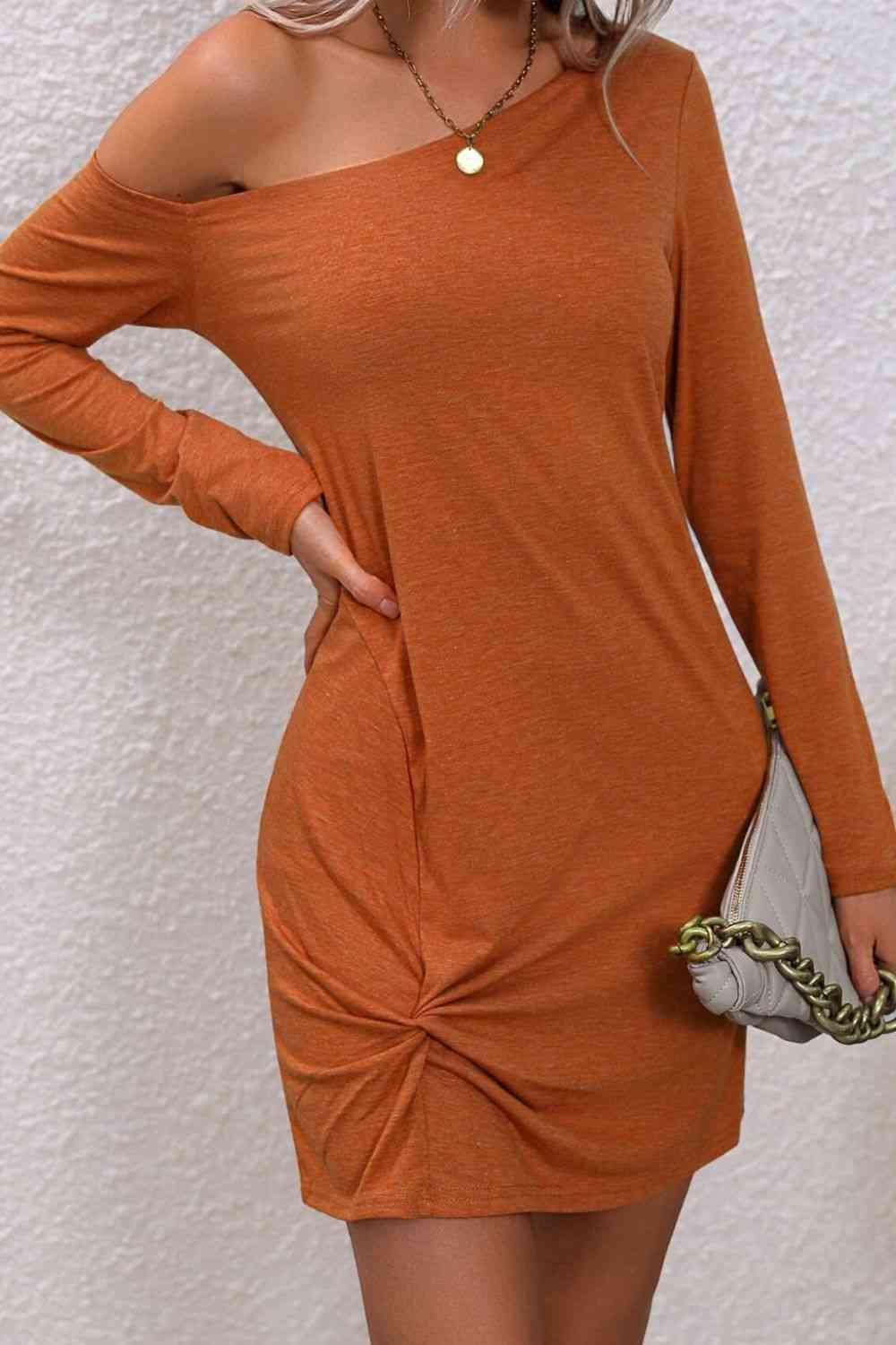 a woman wearing an orange dress with a knot on the side