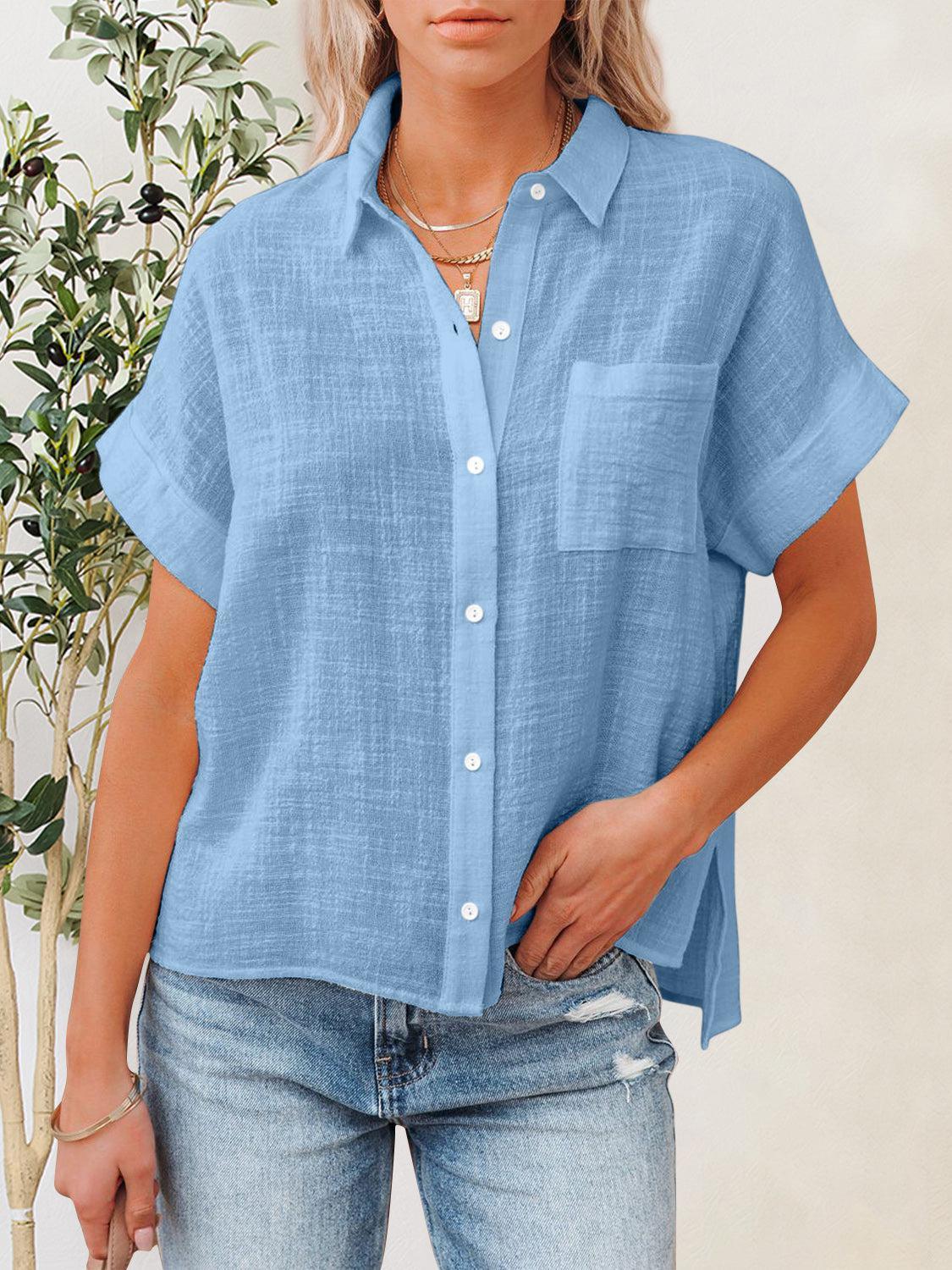 a woman standing next to a plant wearing a blue shirt