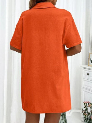 a woman wearing an orange shirt dress