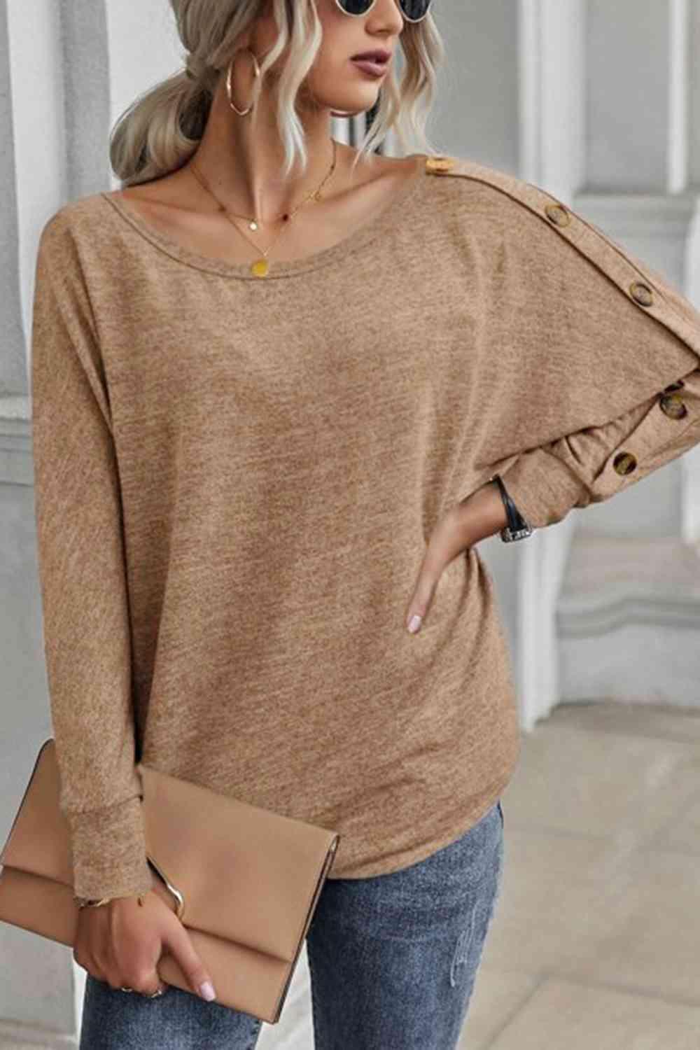 a woman wearing a brown sweater and jeans
