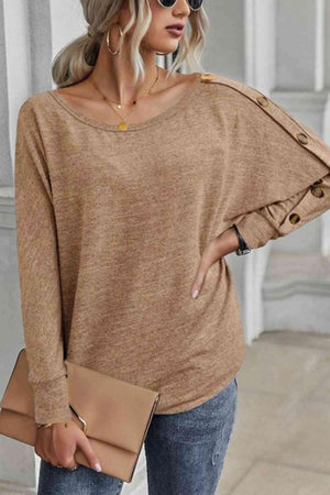 a woman wearing a brown sweater and jeans