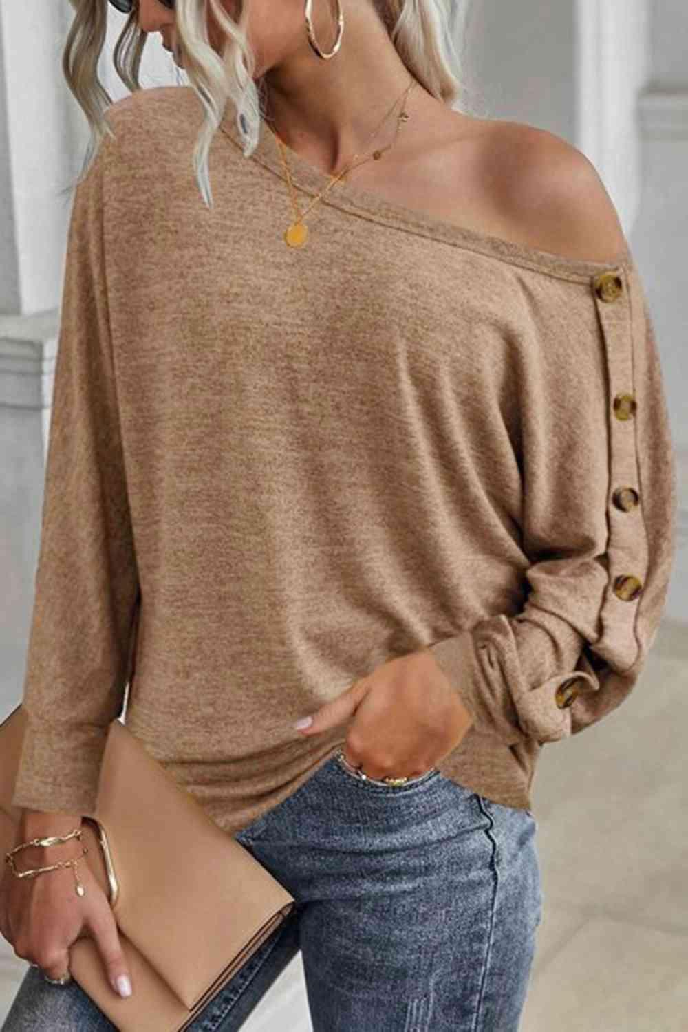 a woman wearing a brown sweater and jeans
