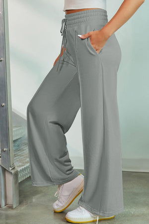 a woman in a white top and grey pants