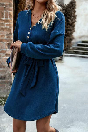 a woman wearing a blue dress and black boots