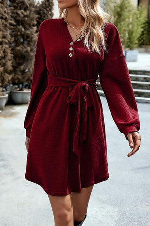 a woman in a red dress is walking down the street