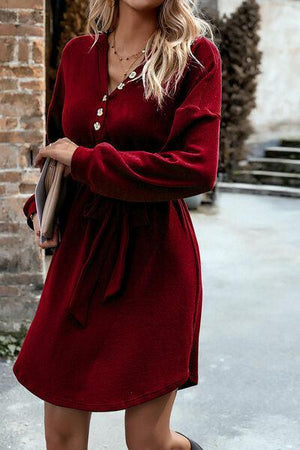 a woman wearing a red dress and black boots