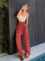 a woman leaning against a wall next to a pool