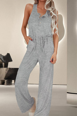 a woman in a grey jumpsuit posing for a picture