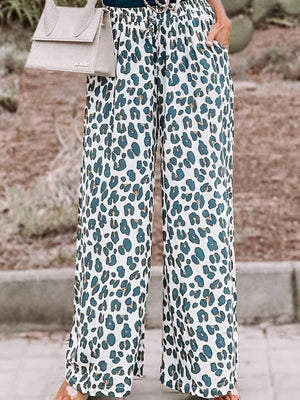 a woman wearing a blue top and leopard print pants