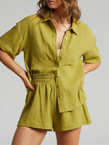 a woman wearing a green shirt and shorts