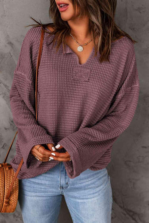 a woman wearing a purple sweater and jeans