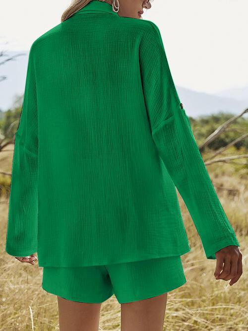 a woman standing in a field wearing a green shirt and shorts