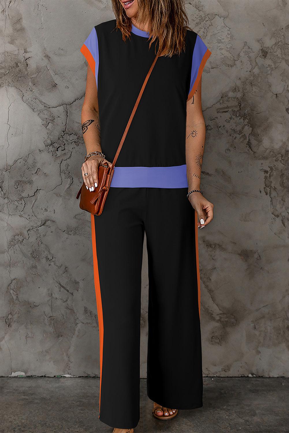 a woman in a black and orange jumpsuit holding a purse