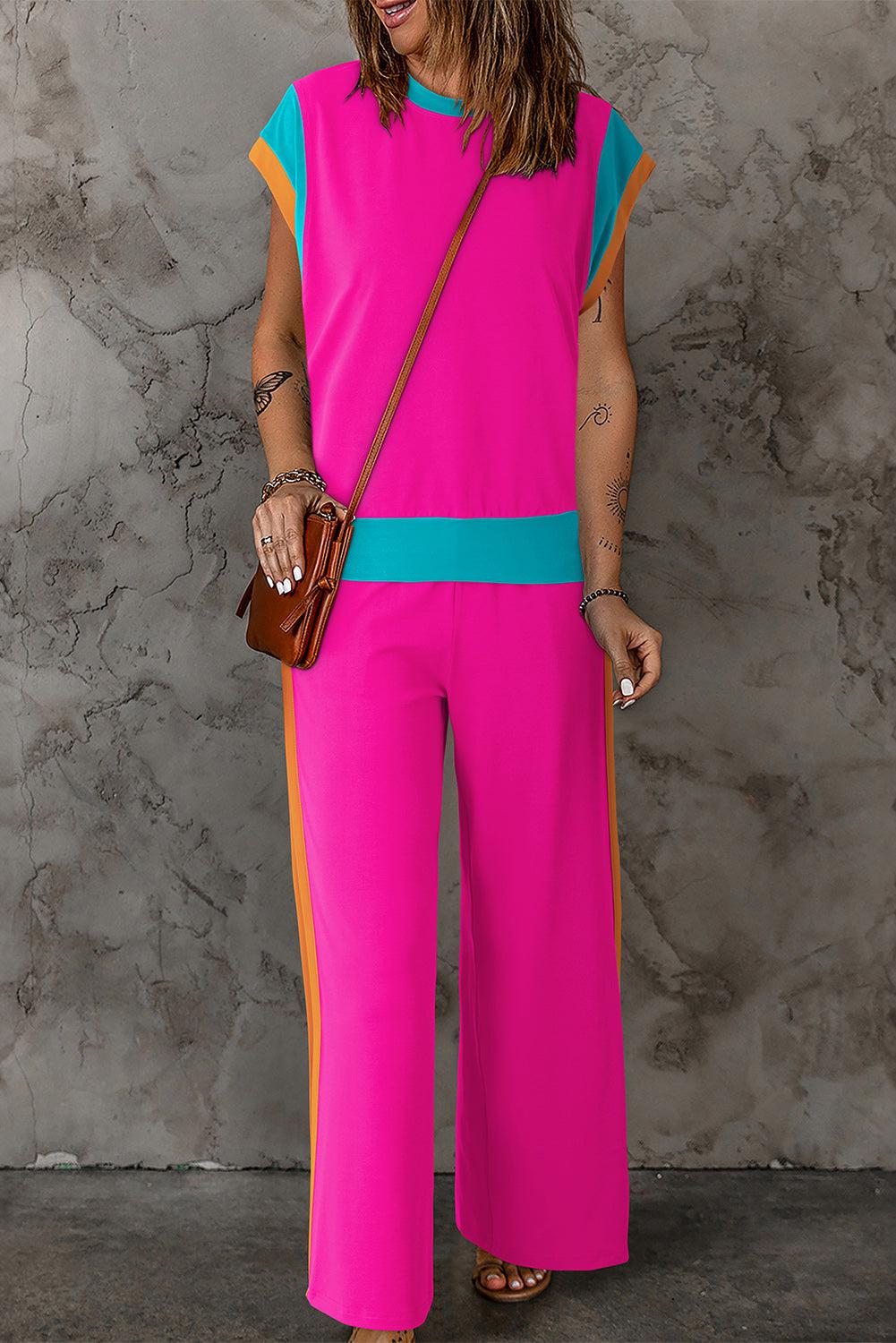 a woman in a pink and blue jumpsuit holding a purse