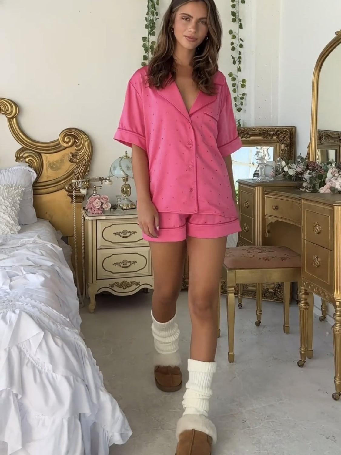 a woman in a pink shirt and shorts standing in a bedroom