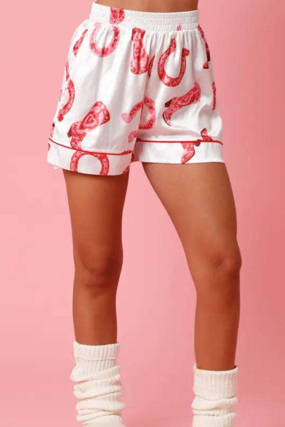 a woman wearing white shorts with red lobsters on them
