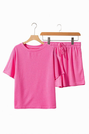 two pieces of pink clothing hanging on a rack