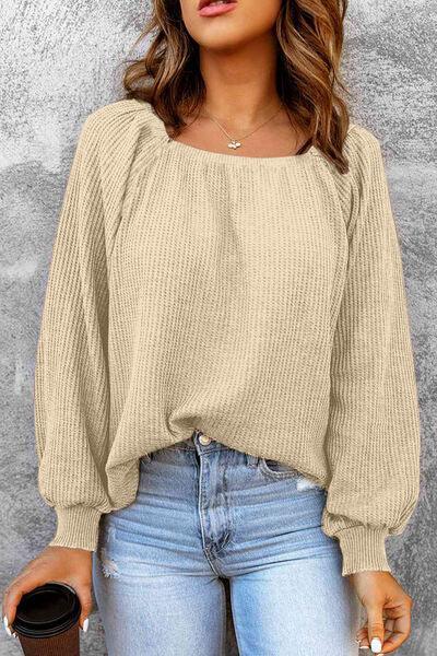 a woman wearing a beige sweater and jeans