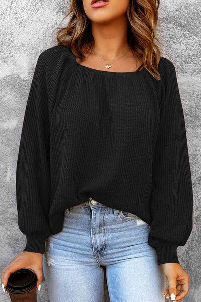 a woman wearing a black sweater and jeans