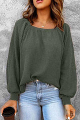 a woman wearing a green sweater and jeans