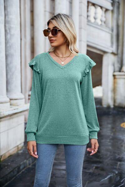 a woman wearing a green sweater and jeans