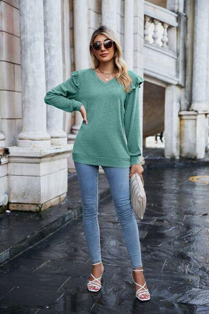 a woman wearing a green sweater and jeans