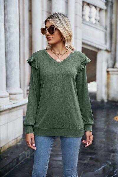 a woman wearing a green sweater and jeans