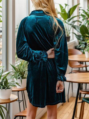 a woman in a green robe standing in a room