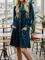 a woman standing in a room wearing a green dress