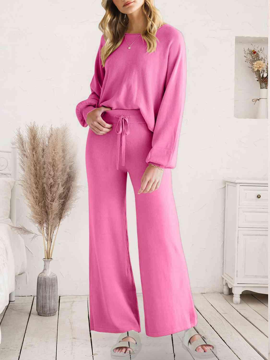 a woman in a pink jumpsuit standing on a wooden floor