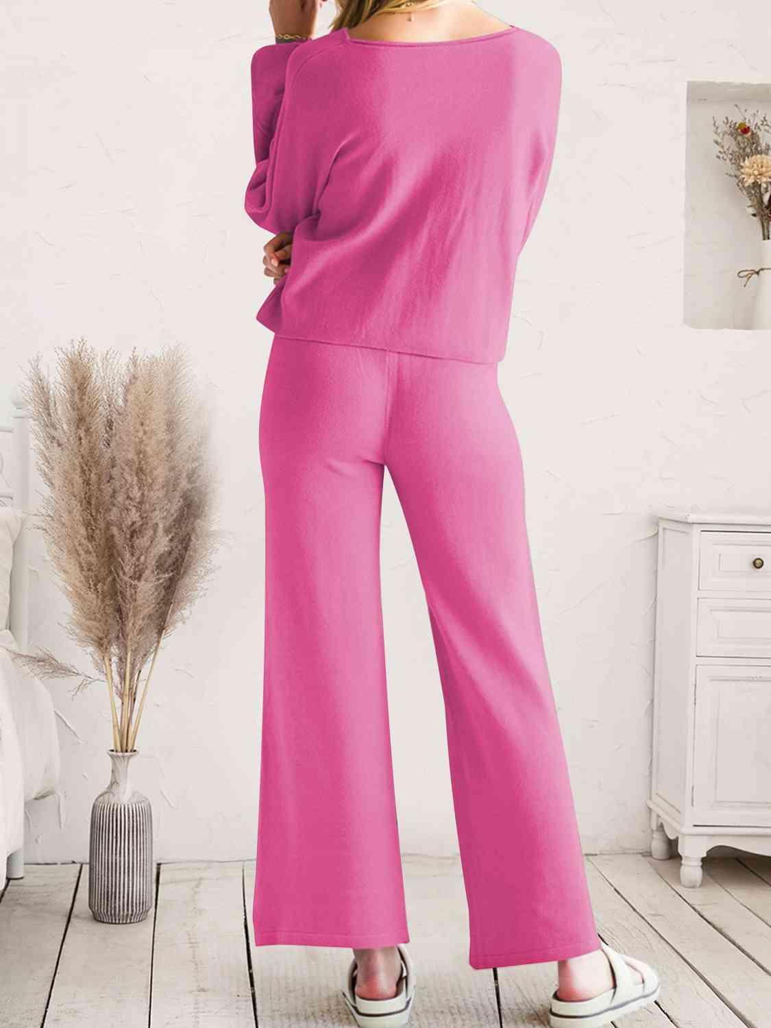 a woman in a pink top and wide legged pants