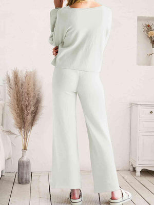 a woman in a white top and wide legged pants