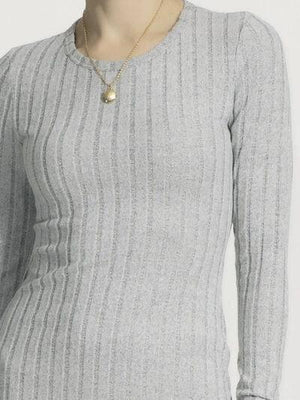 a woman is wearing a sweater and a necklace