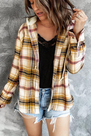 a woman wearing shorts and a plaid jacket