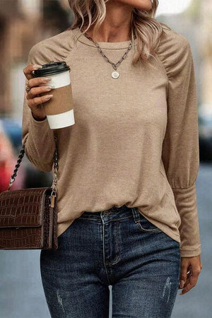 a woman walking down a street holding a cup of coffee