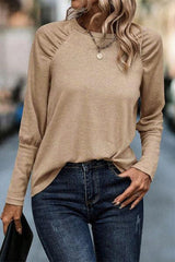 a woman wearing a tan top and jeans