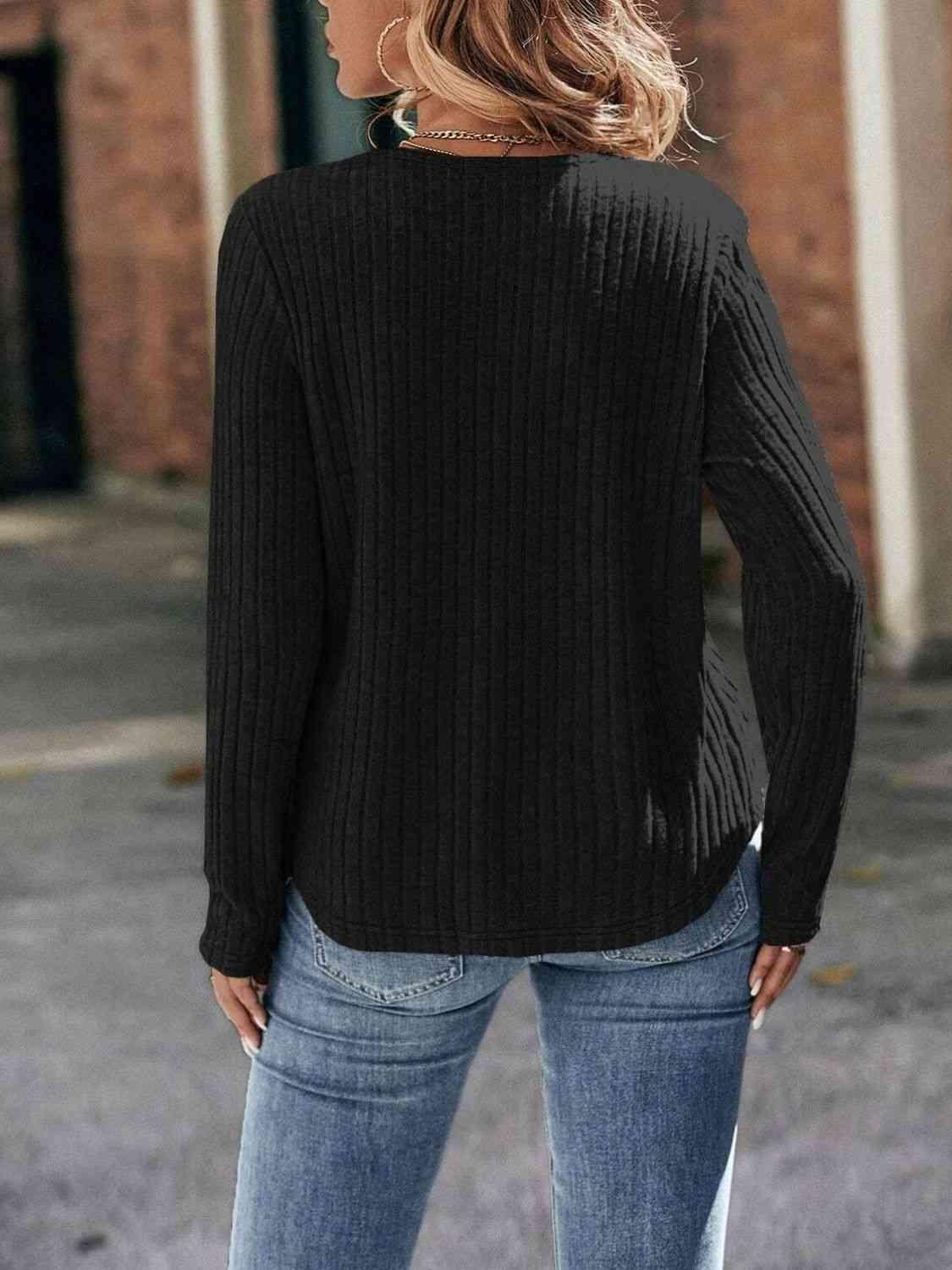 a woman wearing a black sweater and jeans