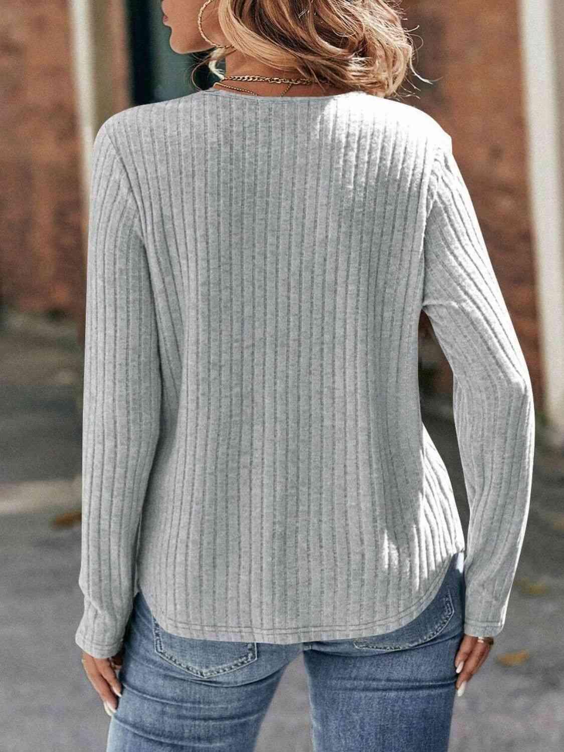 a woman wearing a gray sweater and jeans