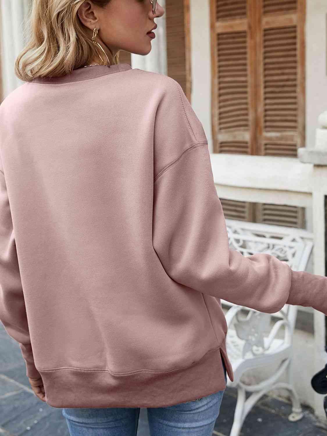 a woman wearing a pink sweatshirt and jeans